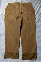 Back view of Carhartt brown work pants showing pockets and overall condition