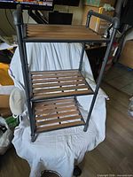 Full view of 3-tier metal rack with slatted shelves