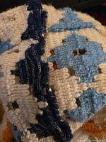 Close view of blue and cream crochet motif detailing