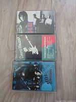 Front view of all three cassette cases showing album artwork