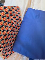 Pepsi-Cola patterned fabric and solid blue fabric displayed side by side