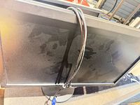 Rear view of BenQ GL2450 monitor with VGA cable draped over top, shows dust on back panel