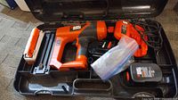 Case open showing nailer, charger, battery, nails