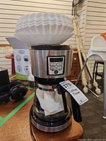 Front view of coffee maker with carafe and filters