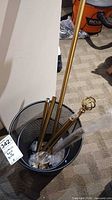 Brass curtain rod segments and finials in mesh bin