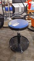 Full view of stool showing seat, pedestal, base and casters