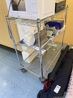 Full view of chrome wire shelving cart showing three shelves and casters