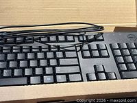 Keyboard inside box showing keys, cable, Dell logo
