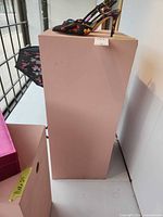 Front and top view of pink pedestal, shoe and note visible