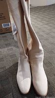 Front view of both boots standing upright with tags visible