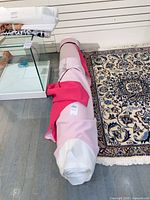 Entire fabric bolt on floor beside rug, showing rolled layers and size