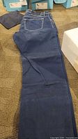 Pair of blue jeans laid flat showing full length and contrast stitching