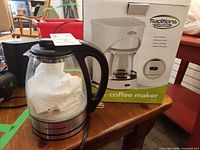 Hamilton Beach kettle beside Traditions coffee maker box