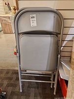 Both folding chairs closed and stacked upright