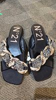 Pair of N°21 black satin slide sandals showing chain embellishment and tags