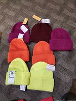 Eight preneLOVE cuffed beanies in four colors laid out with tags visible