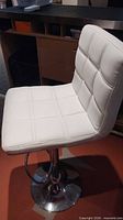 Front angled view of stool showing seat, backrest, base