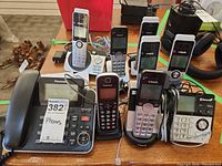 Group shot showing Panasonic corded phone, six VTech handsets, VTech base, cradles and cables