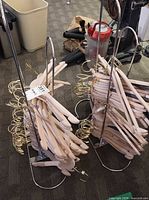 Two floor racks loaded with numerous wooden hangers