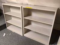 Two gray HON metal bookcases side by side