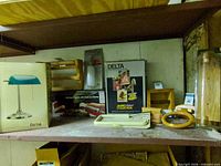 Shelf showing boxed Dana lamp, Delta faucet, oak accessories