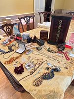 Overall lot showing armoire, jewelry pieces spread on table