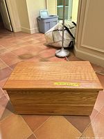 Front view of closed light oak chest