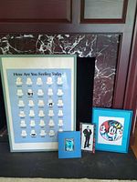 Group shot showing all four framed artworks leaning against fireplace