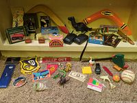 Overall view of entire lot with toys, walkie-talkies, boomerangs, plush dinosaur and small items