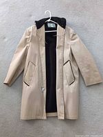 Full front view of coat showing length, color, pockets, and lining