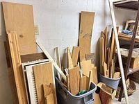 Two totes and loose boards containing mixed oak flooring scraps, trim pieces, cabinet panels