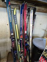 All skis and poles leaning against wall