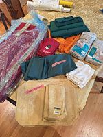 Overview of all linens, chair covers in packaging, gold placemats and burgundy drapes