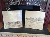 Two square landscape paintings on fireplace hearth showing size and pair