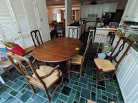 Dining table with five chairs arranged around it
