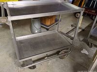 Full view of stainless steel two-tier cart on wheels