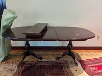 Full view of dining table with one leaf inserted and second leaf resting on top