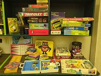 Shelf showing majority of boxed board games, puzzles and accessories