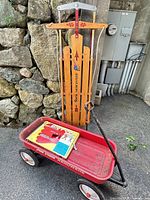Sled standing upright, wagon on ground with snowshoe box inside