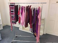 Full clothing rack showing all garments in rosy hues