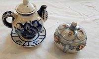 Overview of teapot with saucer and lidded sugar jar