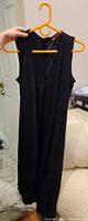 Full view of black sleeveless maxi dress on hanger