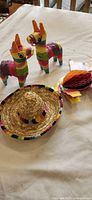 Sombrero, two mini piñatas and folded honeycomb decorations displayed together