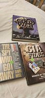 Three hardcover books with dust jackets visible
