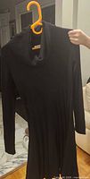 Black Calvin Klein ribbed knit cowl-neck dress on hanger