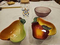 Group shot of two ceramic fruit bowls, glass bowl, and printed tumbler