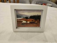Front view of framed oil painting showing artwork and white frame