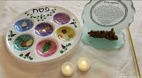 Seder plate, glass plaque and two tea lights displayed together