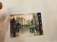 front view of small framed cityscape painting