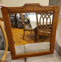 Front view of rectangular wood-framed wall mirror